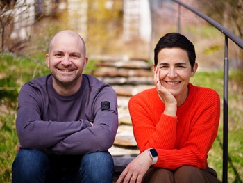 Marianne und Christian Daberer sitzen auf einer Treppe im Garten
