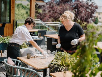 Restaurant-Mitarbeiter im Daberer decken einen Tisch
