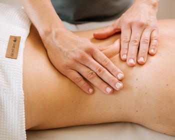Person bekommt eine Rückenmassage