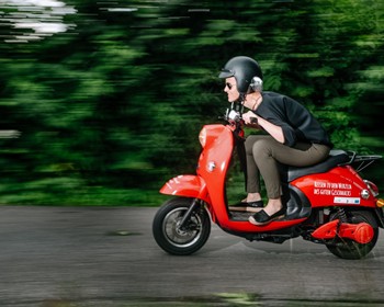 Frau auf rotem Roller
